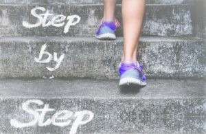 Step by Step - Frau geht mit Turnschuhen die Treppe hinauf